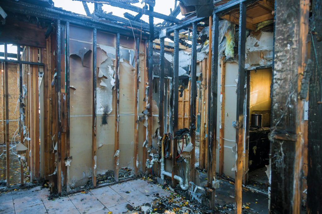 Burnt wooden walls house with charred roof burnt fire damaged interior details